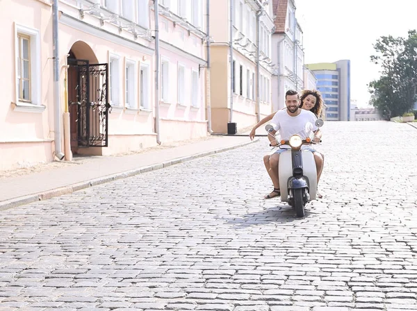 Happy young couple having fun on a scooter — Stock Photo, Image