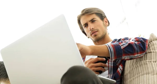 Fotoğraf genç adam ile smartphone bir sandalyede oturuyor. bulanık bir arka plan üzerinde — Stok fotoğraf