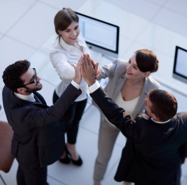 Başarılı bir iş ekibi ofiste birbirlerine beşlik çakıyor.