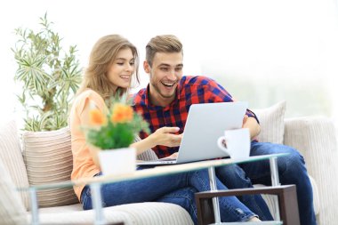 Genç çift bir dizüstü bilgisayar ekranına bakarak