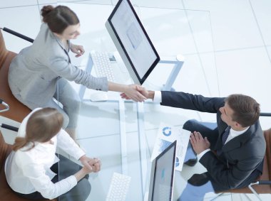 En baştan görüntüleyin. iş el sıkışma adamı ve subay masanın üstünde.