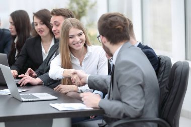 Menajer ve müşteri el sıkışarak birbirlerini selamlıyorlar.