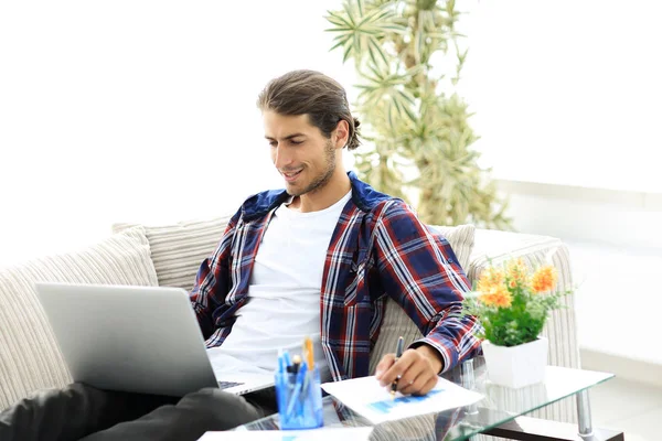 Впевнений хлопець працює з ноутбуком з дому. концепція фрілансу — стокове фото
