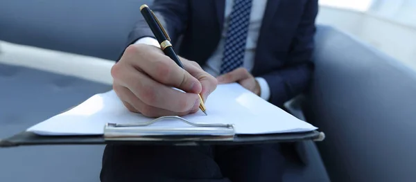 O empresário assina um contrato. Segurando a caneta na mão . — Fotografia de Stock