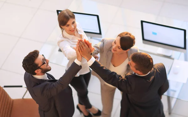 Odnoszący sukcesy zespół biznesowy przybija sobie piątkę, stojąc w biurze — Zdjęcie stockowe