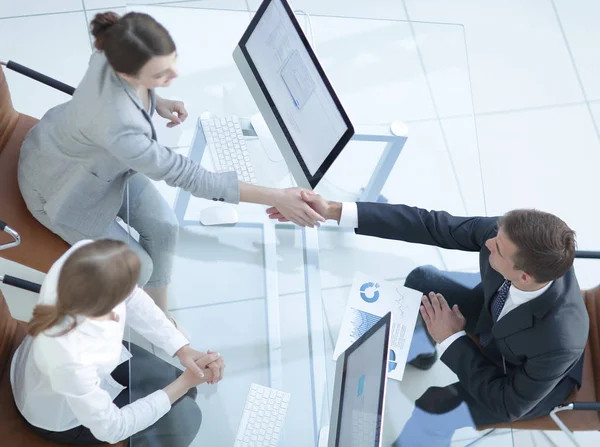 En baştan görüntüleyin. iş el sıkışma adamı ve subay masanın üstünde.