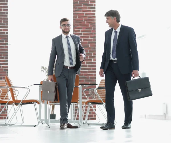 Zwei Geschäftsleute laufen in modernem Bürogebäude mit — Stockfoto