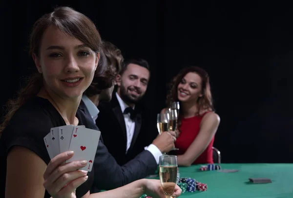 Porträtt av den kvinnliga spelaren vid pokerbordet med kort — Stockfoto