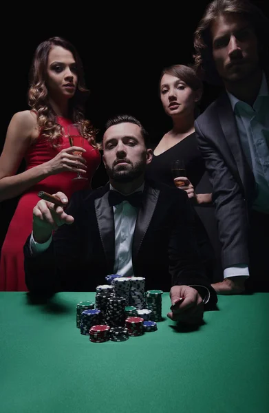 Homem emocional de terno sentado à mesa de poker e gesticulando — Fotografia de Stock