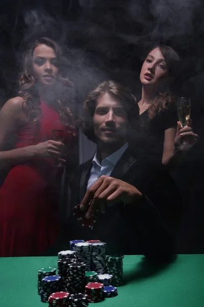 Fortunate gambler surrounded by seductive elegant women — Stock Photo, Image