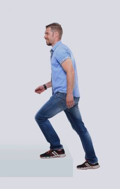 Beyaz arka plan üzerinde merdiven yukarı mavi tişörtlü Casual adam