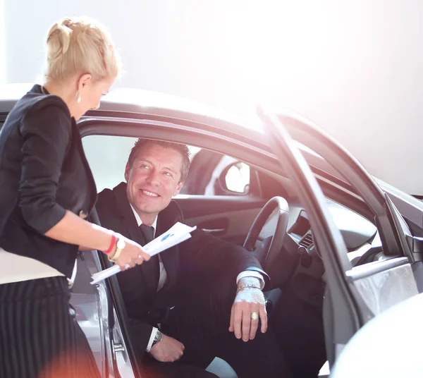Handsome mature man buying a car at dealership — Stock Photo, Image
