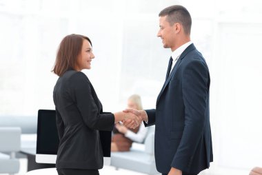 Pazarlık masasında el sıkışan iş ortakları.