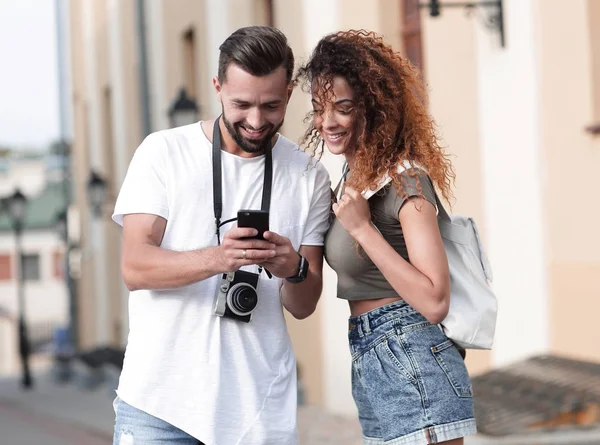 Молодая пара приезжает в город летом и смотрит фотографии — стоковое фото