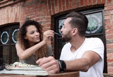 Genç bir çift bir sokak kafede kahve zevk ve gülüyor