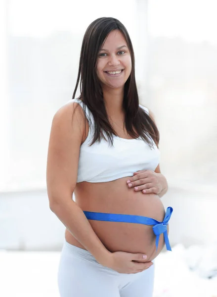 Šťastná těhotná žena měří své břicho a pas. — Stock fotografie