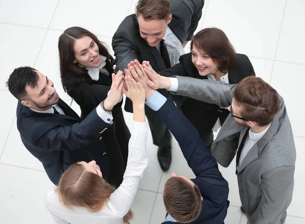 Närbild. glad affärsteam med vikta händer tillsammans — Stockfoto