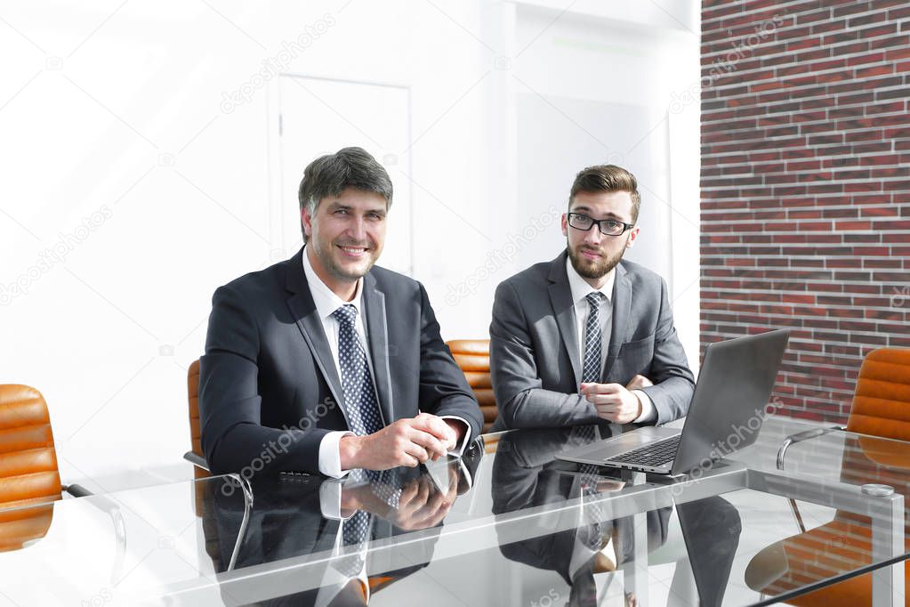 Two successful employees sitting at the desk