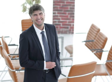 Bir boş toplantı odasında duran iş adamı