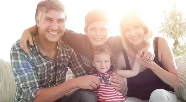 Щаслива сім'я з чотирьох сидить на дивані — стокове фото