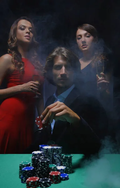 Fortunate gambler surrounded by seductive elegant women — Stock Photo, Image