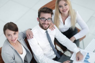 masada oturan ve kameraya bakarak başarılı iş takım.