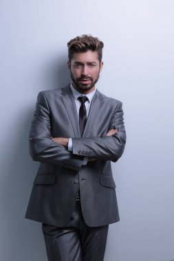 Çapraz kollarla poz veren genç iş adamı.