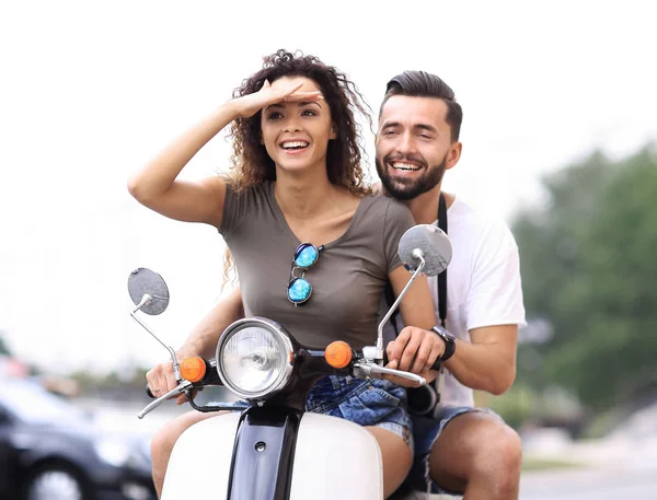 Hermosa pareja joven sonríe mientras monta un scooter — Foto de Stock