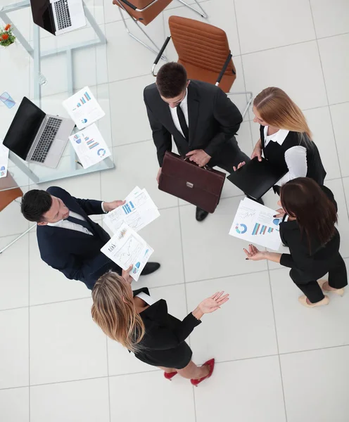 Vue de l'équipe top.business discutant des graphiques marketing, debout dans le bureau . — Photo