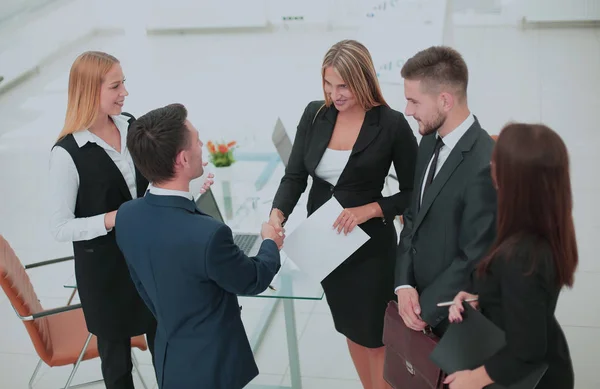 Vista desde arriba: equipo de negocios de pie en una oficina y shaki — Foto de Stock