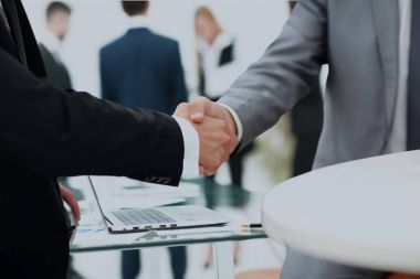 bir anlaşma üzerinde el sıkışan iş adamları