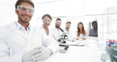 Erkek bilim adamı ve laboratuarda takım.