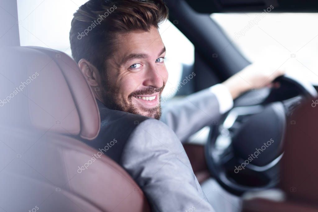 Successful man sitting behind the wheel of a prestigious car