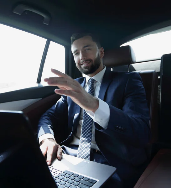 車の後部座席に座っていると前方に彼の指を指してビジネスマン — ストック写真
