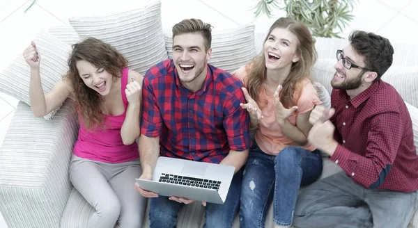 Gruppe von Freunden schaut sich ein Video auf einem Laptop an und lacht — Stockfoto