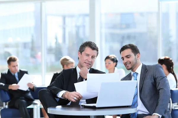 Geschäftspartner diskutieren Finanzfragen in der Lobby der Bank — Stockfoto