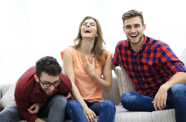 Группа молодых людей смеется и сидит на диване — стоковое фото