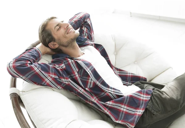 Modern adam büyük bir rahat sandalyede oturuyor dinleniyor. yan görünüm.