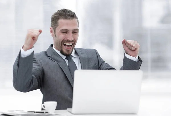 Close seup.happy businessman sitting in front of an open laptop . — стоковое фото