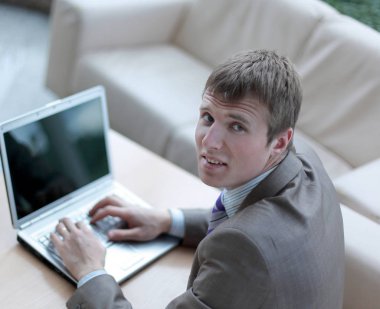 Bir dizüstü bilgisayarda çalışan takım elbiseli genç adam Üstten Görünüm