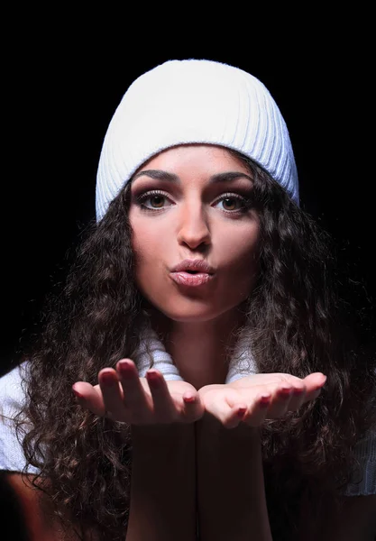 Retrato de una chica en un sombrero de punto blanco envía un beso — Foto de Stock