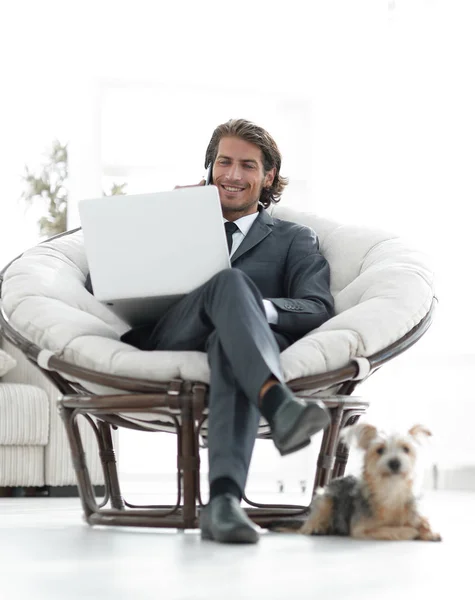 Hombre de negocios exitoso trabajando en un ordenador portátil y hablando en un teléfono inteligente — Foto de Stock