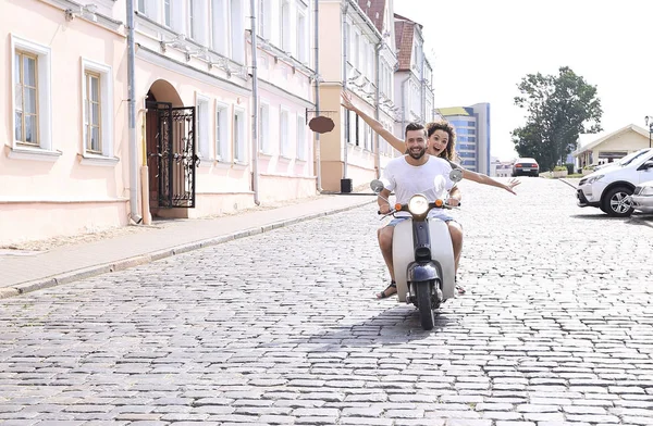 Feliz pareja joven divirtiéndose en un scooter — Foto de Stock