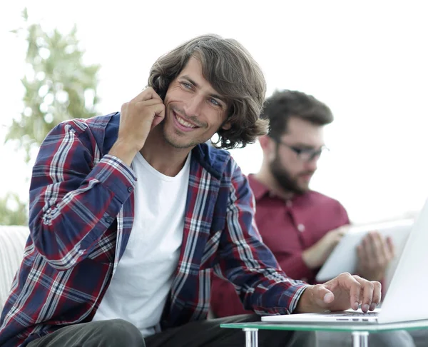Guy with a friend sitting at the desk. — Stock Photo, Image