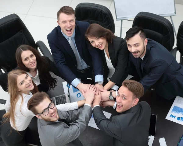 Equipe de negócios com as mãos apertadas juntas na mesa — Fotografia de Stock