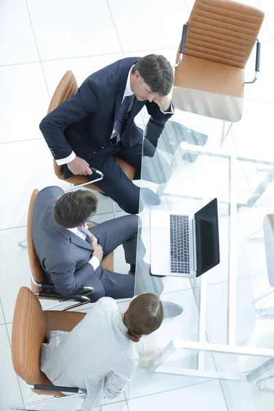 Tre affärsmän, möte runt ett styrelserum bord — Stockfoto