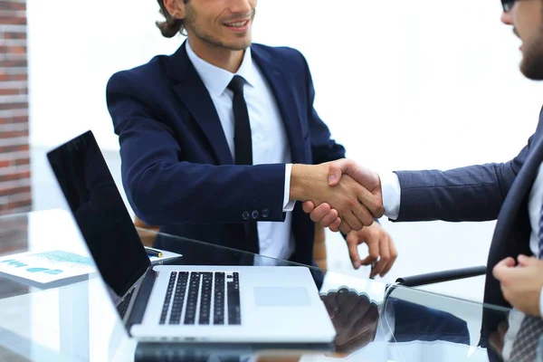 Parceiros de negócios handshake na frente do laptop aberto — Fotografia de Stock