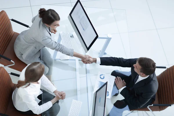 Utsikt från toppen. handshake affärsman och officer ovanför bordet. — Stockfoto