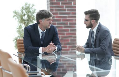 iki işadamı görevleri Office masada oturan tartışıyor.