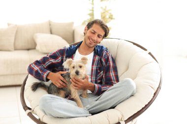 yakışıklı olan büyük bir koltukta oturan bir köpekle.